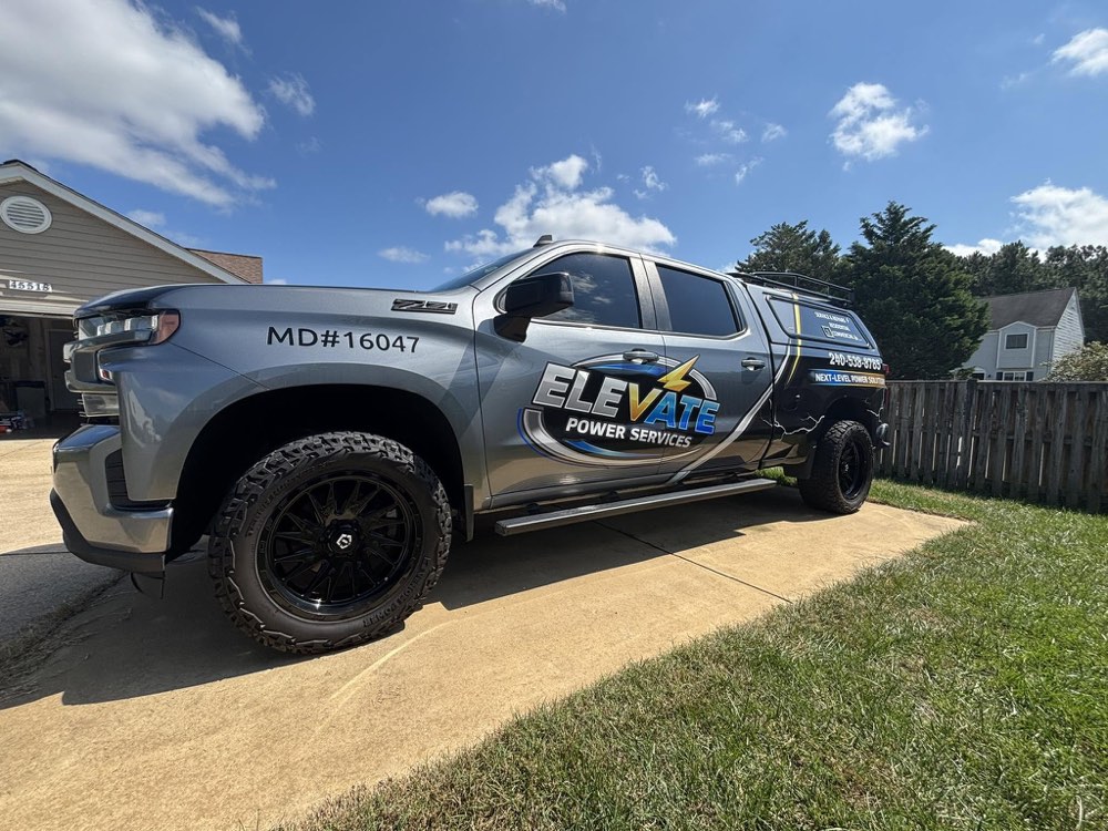The Elevate Power Services work truck, wrapped with the logo and Maryland license number, parked in a driveway